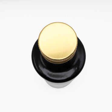 Black bottle with a gold cap on a white background