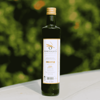 Bottle of Portugues olive oil on a white surface with a green blurred background