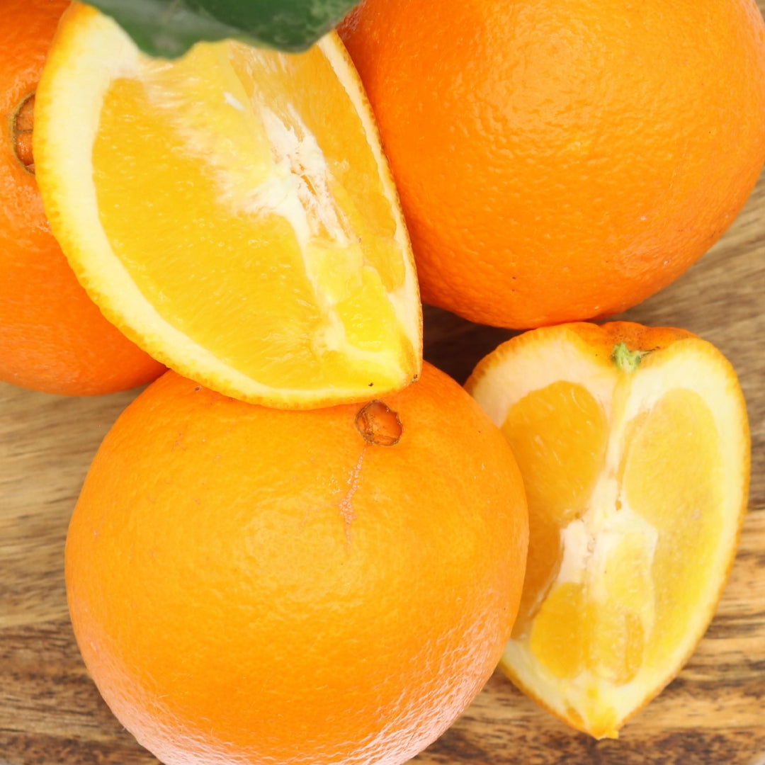 Ripe Algarve oranges with sliced pieces on a wooden board. Enjoy a 1 kg mixed box of fresh citrus fruits, perfect for a natural, sweet taste.