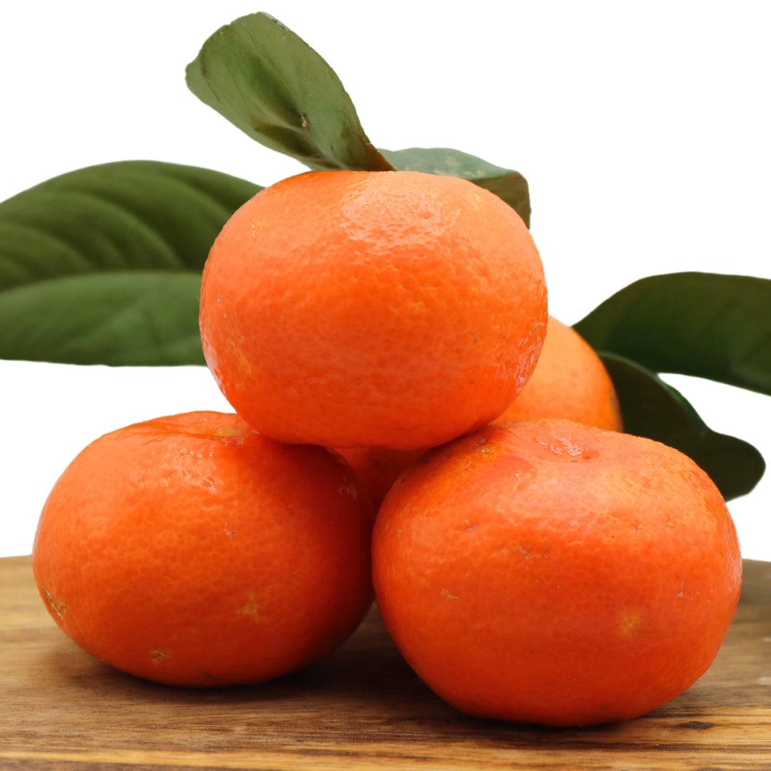 Juicy Algarve tangerines with green leaves, stacked on a wooden board. Buy a 1 kg mixed box of fresh oranges and tangerines for a citrus delight.