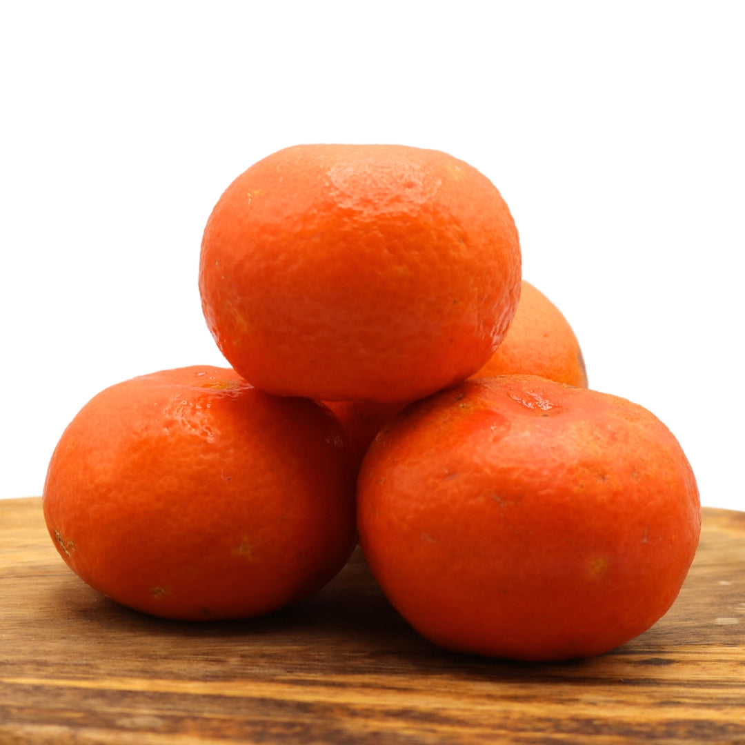 Juicy Algarve tangerines, stacked on a wooden board. Buy a 1 kg mixed box of fresh oranges and tangerines for a citrus delight.