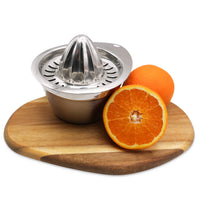 Stainless steel manual juicer on a wooden cutting board with oranges