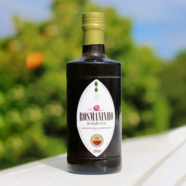 Bottle of Rosmaninho Biologico olive oil on a table with a blurred natural background