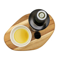 Bottle and bowl of olive oil on a wooden board with a white background