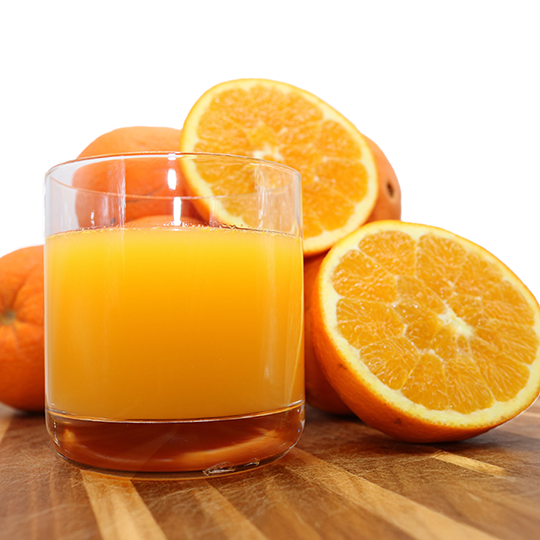 Ripe Algarve oranges with sliced pieces and a glass of juice. Enjoy fresh citrus fruits, perfect for a natural, sweet taste. 