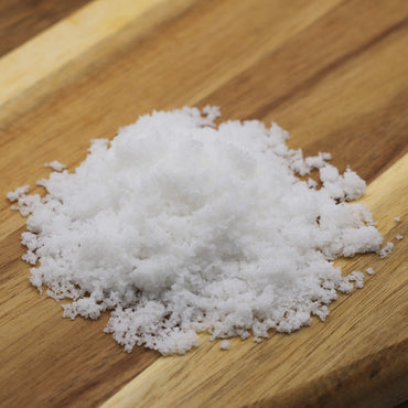 White organic sea salt Fleur de sal on a wooden surface
