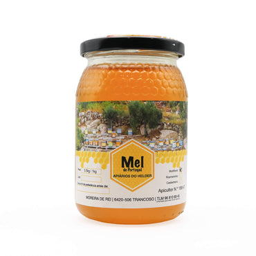Jar of honey with a label featuring a scenic image and brand name on a white background