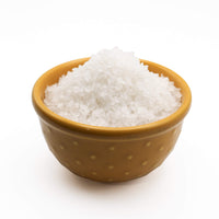 Brown bowl filled with white salt on a white background